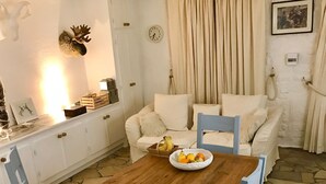 A cozy dining area with a wooden table, chairs, and a bowl of fruit.