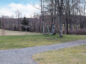 A park with a gravel path, a swing set, and leafless trees. - 11 Person Holiday Home in Hogsater (Högsäter)