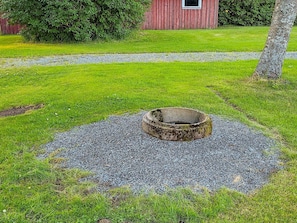 A circular gravel area with a central depression, surrounded by grass, with a red building and a tree in the background. - 11 Person Holiday Home in Hogsater (Högsäter)