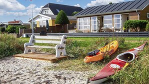Una playa con kayaks y un banco.