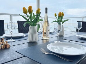 A table set for dining with white plates, silverware, and vases with yellow tulips.