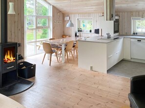 A modern kitchen with a central island, wooden flooring, and large windows. - 4 Star Holiday Home in Hals (Hals)