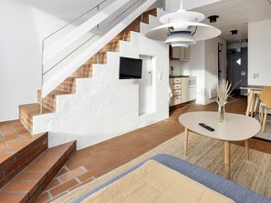 A modern living space with a staircase, a dining area, and a kitchen.
