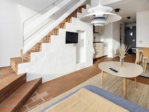 A modern living space with a staircase, a dining area, and a kitchen. - 4 Person Holiday Home in Brovst (Brovst)