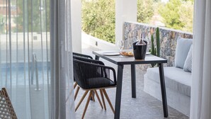 A modern outdoor seating area with a table, chairs, and a view of the sea. - Kaktus Suites Private Pool (Kassandra)