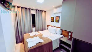 A hotel room with a bed, a nightstand, a wardrobe, and a window with curtains. - 1. Flat Premium Porto de Galinhas (Ipojuca)