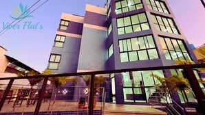 A modern building with large windows and a tiled facade. - 1. Flat Premium Porto de Galinhas (Ipojuca)