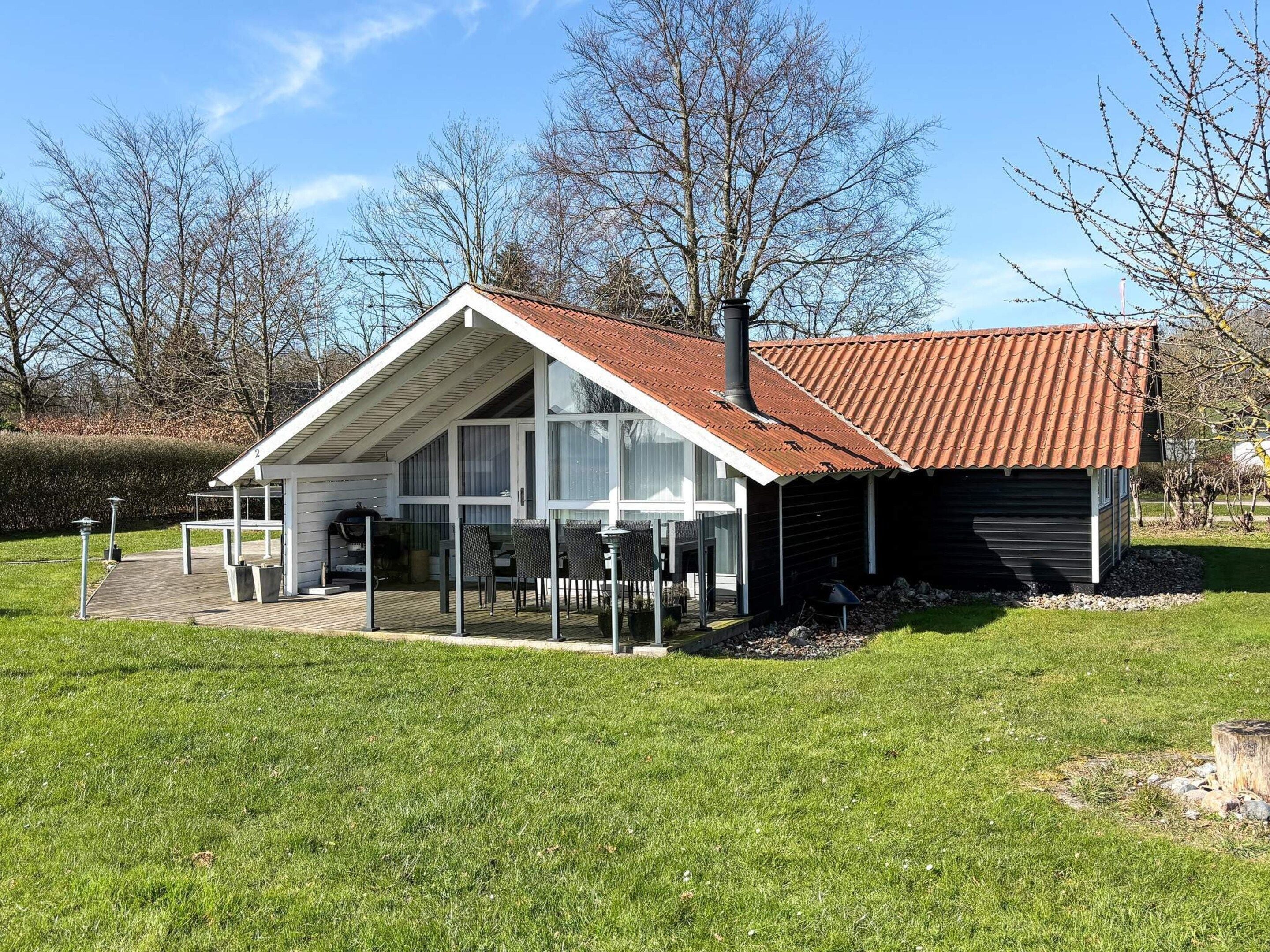 A house with a large porch, a garage, and a well-maintained lawn.