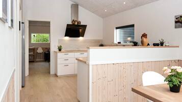 Una cocina moderna con una isla central, armarios de madera y un horno empotrado.