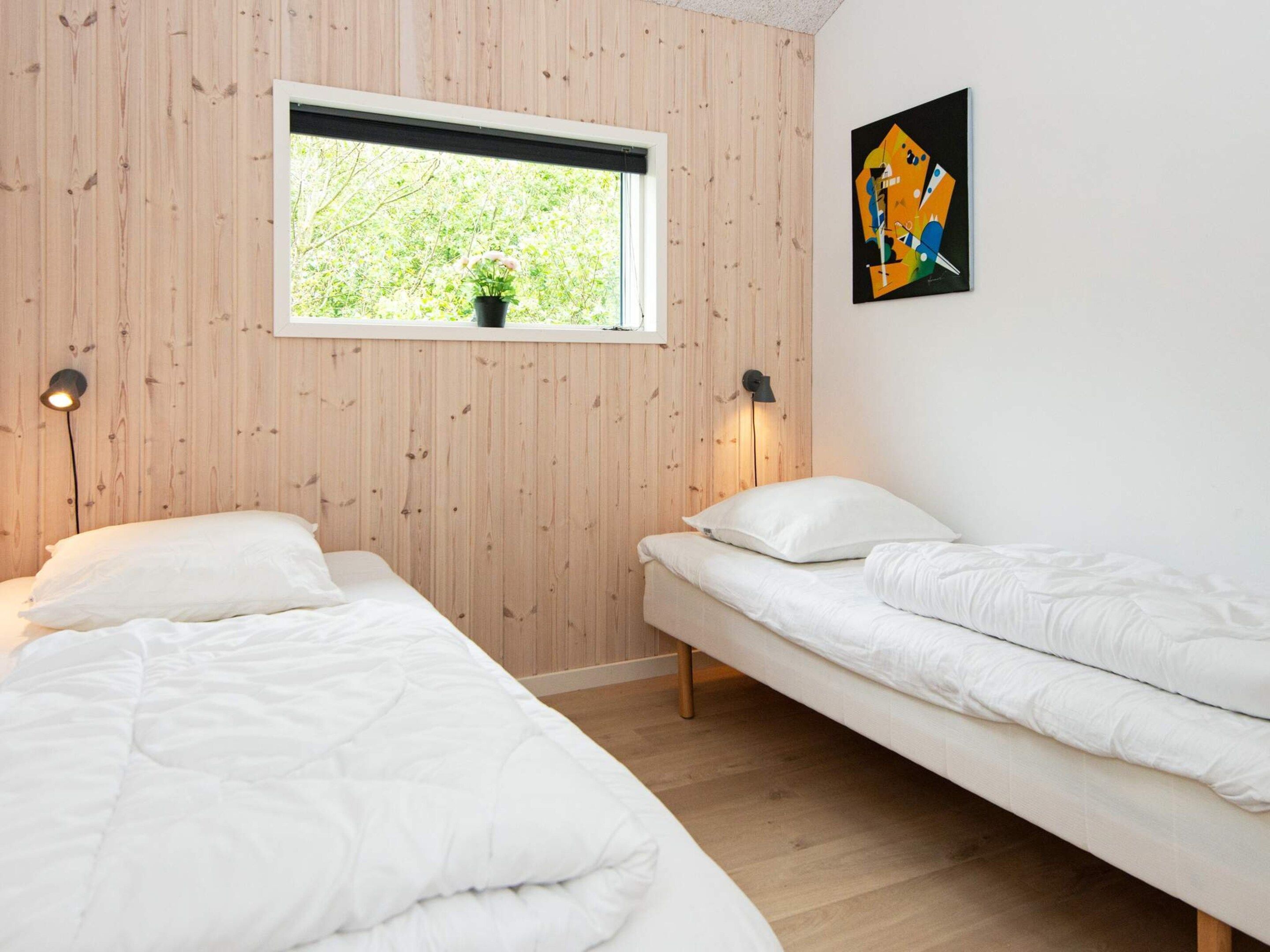 Una habitación con dos camas, una ventana con vista a zonas verdes y una obra de arte abstracta en la pared.