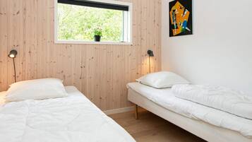 Una habitación con dos camas, una ventana con vista a zonas verdes y una obra de arte abstracta en la pared.