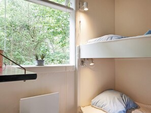A bunk bed with a window, a bedside table, and a potted plant. - 8 Person Holiday Home in Nexo (Nexø)