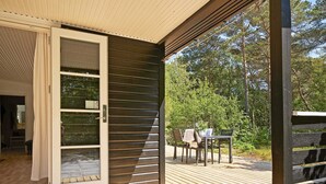 Eine offene Schiebetür führt zu einer Terrasse mit Tisch und Stühlen.
