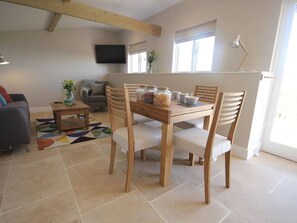 Enjoy meals in the spacious dining area with a wooden table and four chairs.