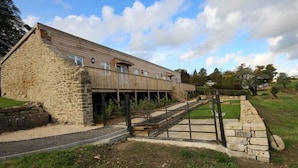 A stone building with a wooden extension, a covered walkway, and a stone pathway leading to a gate. - Stunning location close to city centre - Pass the Keys (Bath)