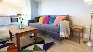 A living room with a sofa, a coffee table, a side table, and a floor lamp. - Stunning location close to city centre - Pass the Keys (Bath)