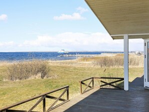 A wooden deck with a view of the sea and a boat.