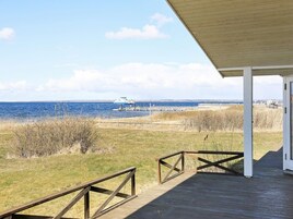 A wooden deck with a view of the sea and a boat.