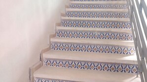 A staircase with patterned tiles and a metal railing.