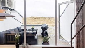 A modern living room with a glass door leading to a patio area. - 4 Person Holiday Home in Brovst-by Traum (Brovst)
