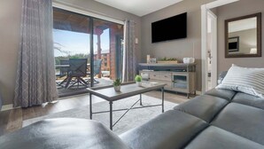 Un salon moderne avec un canapé, une table basse et un téléviseur fixé au mur.