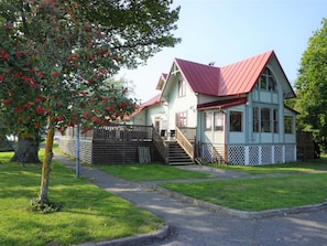 A two-story house with a red roof, a front porch, and a fenced yard. - 4 Person Holiday Home in Ronneby (Ronneby)