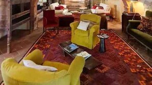 A spacious living area with a high ceiling, a fireplace, and a large arched doorway leading to another room. - Villa under the Tuscan sun (Toscana)