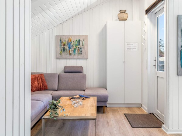A modern living room with a grey sofa, a wooden coffee table, and a painting on the wall.
