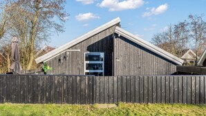 A wooden building with a sloped roof, a large window, and a door. - 4 Person Holiday Home in Hemmet (Hemmet)