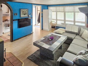 A living room with a sofa, a coffee table, and a television. - 10 Person Holiday Home in Solvesborg (Sölvesborg)