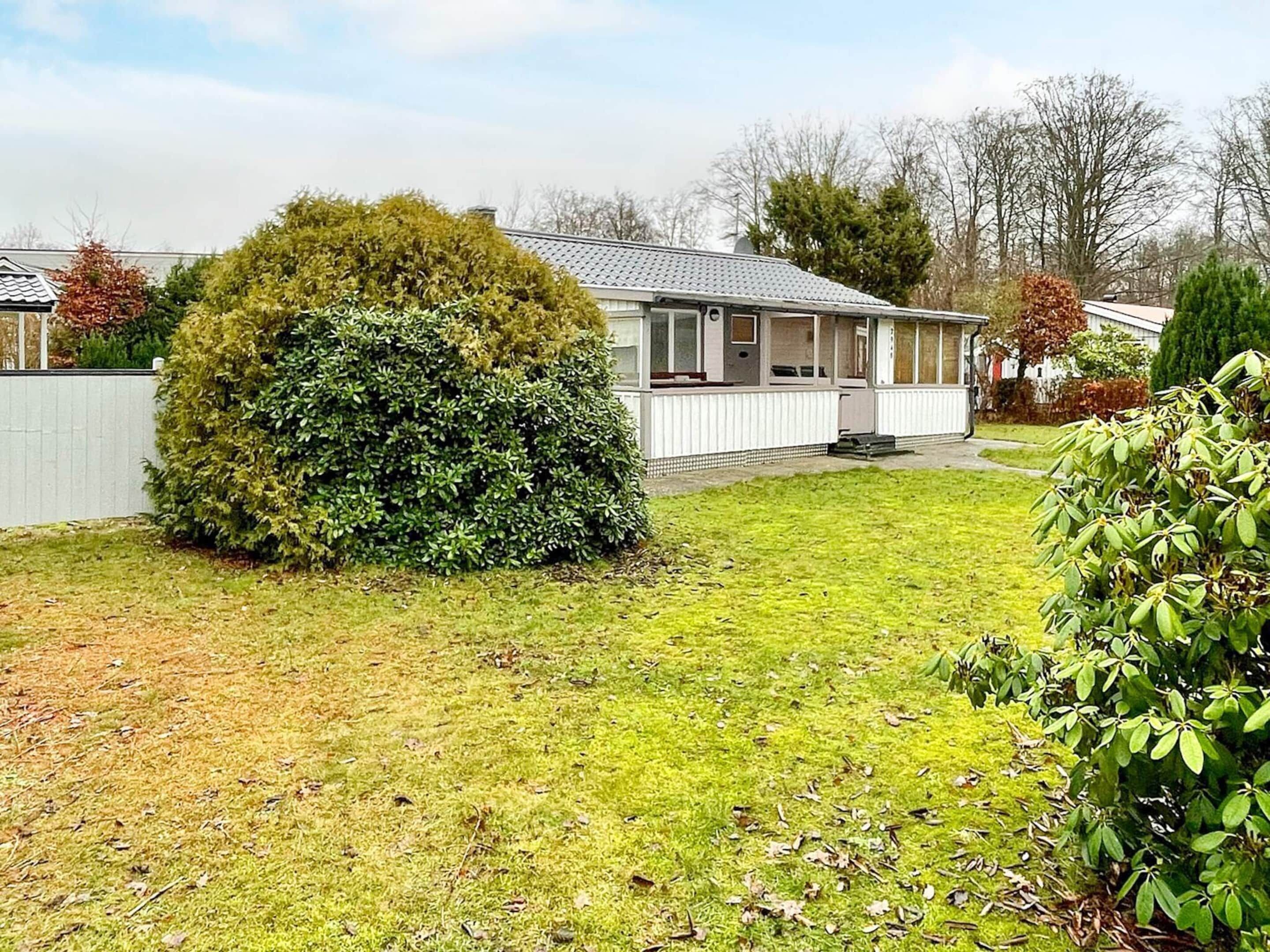 A single-story house with a covered porch, a fenced yard, and a well-maintained lawn.
