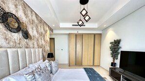 A modern bedroom with a large bed, a TV, and a wardrobe. - LuxBnB Paramount Midtown SeaView (Dubai)