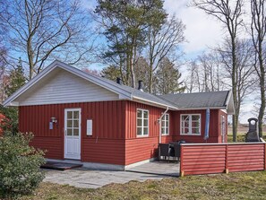 A red wooden building with a white door, windows, and a chimney. - 4 Star Holiday Home in Ronne (Ronne)