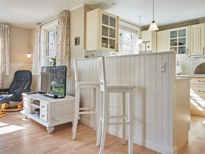 A room with a desk, chair, and a white partition.