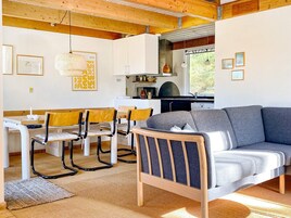 Un interior acogedor con comedor, sofá y zona de cocina.