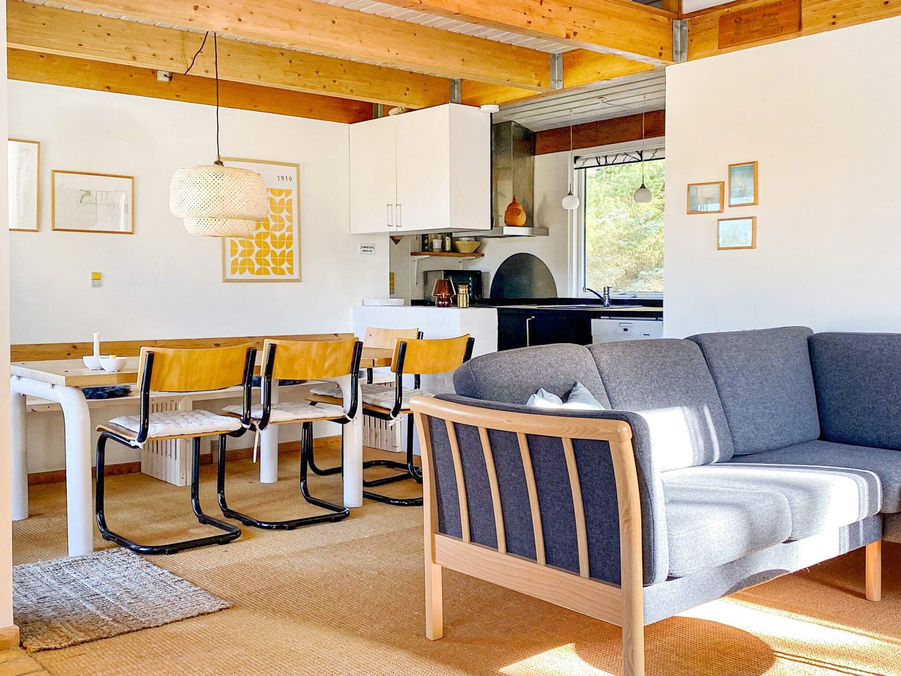 Ein modernes Interieur mit Essbereich, einer Couch und einer Küche.