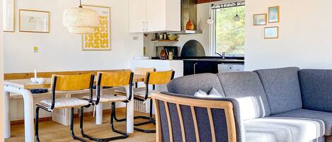 Ein modernes Interieur mit Essbereich, einer Couch und einer Küche.