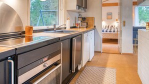 A modern kitchen with a built-in oven, a dishwasher, and a large window providing a view of the outdoors.