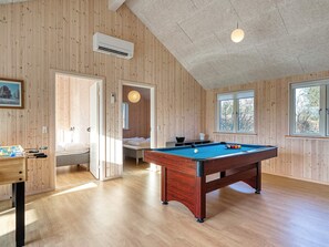 A room with a pool table, a bed, and a futsal table.