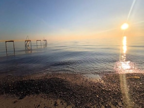 A beach with a clear sky and the sun setting over the water. - 8 Person Holiday Home in Dannemare (Dannemare)