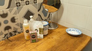 Un meuble-lavabo de salle de bain avec un miroir, des articles de toilette et un récipient.