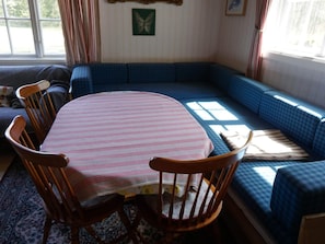 A cozy living room with a round table, wooden chairs, a blue sofa, and a patterned rug. - 5 Person Holiday Home in Mullhyttan (Mullhyttan)