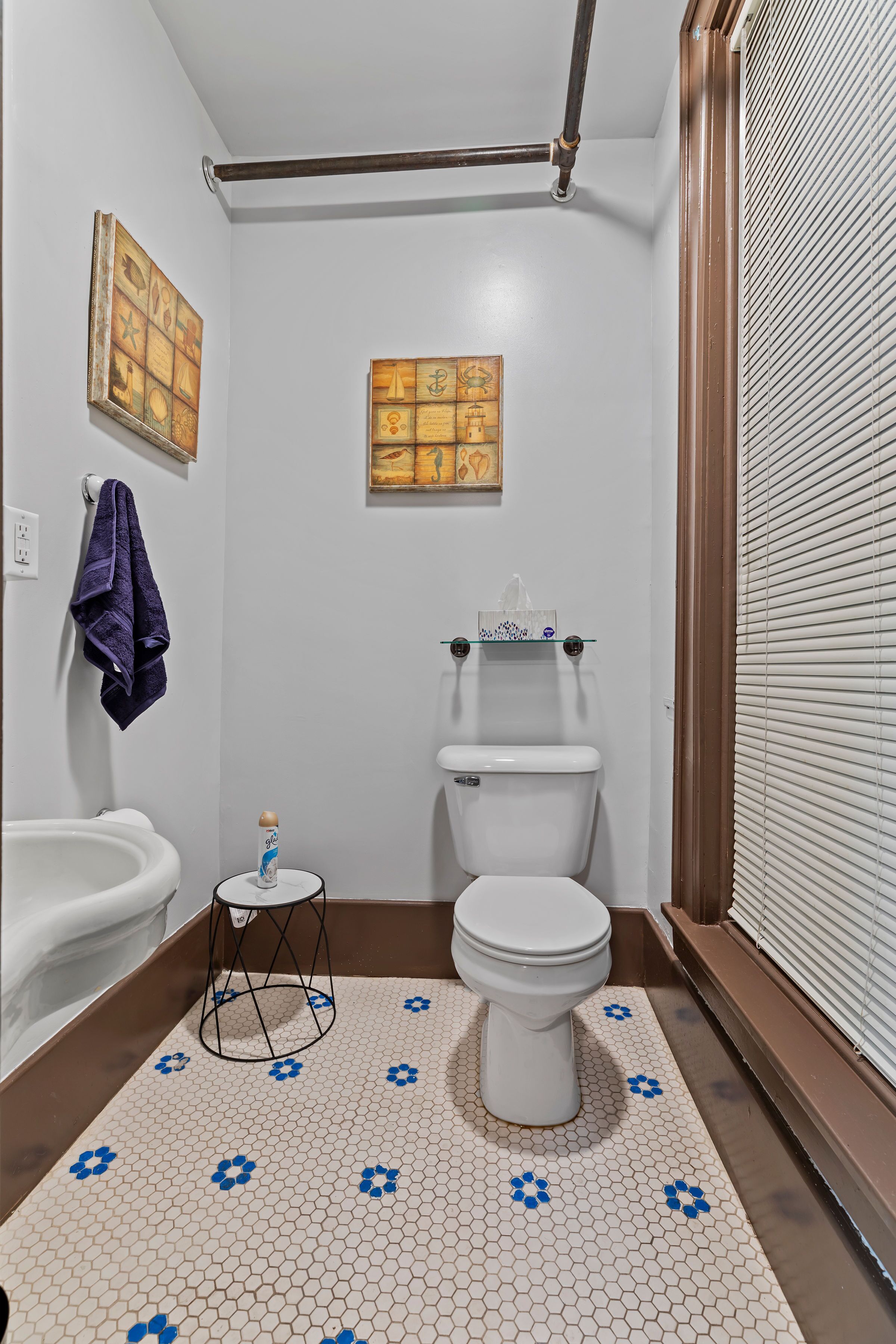 Un bagno con il water, un lavandino e uno sgabello.