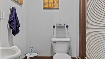 Un bagno con il water, un lavandino e uno sgabello.