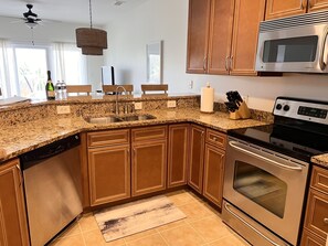 A kitchen with granite countertops, stainless steel appliances, wooden cabinets, and a built-in oven.