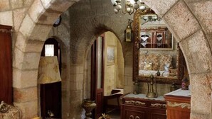 A room with stone arches, antique furniture, and a large mirror. - Megiston House in Old Town Rhodes (Rhodes)