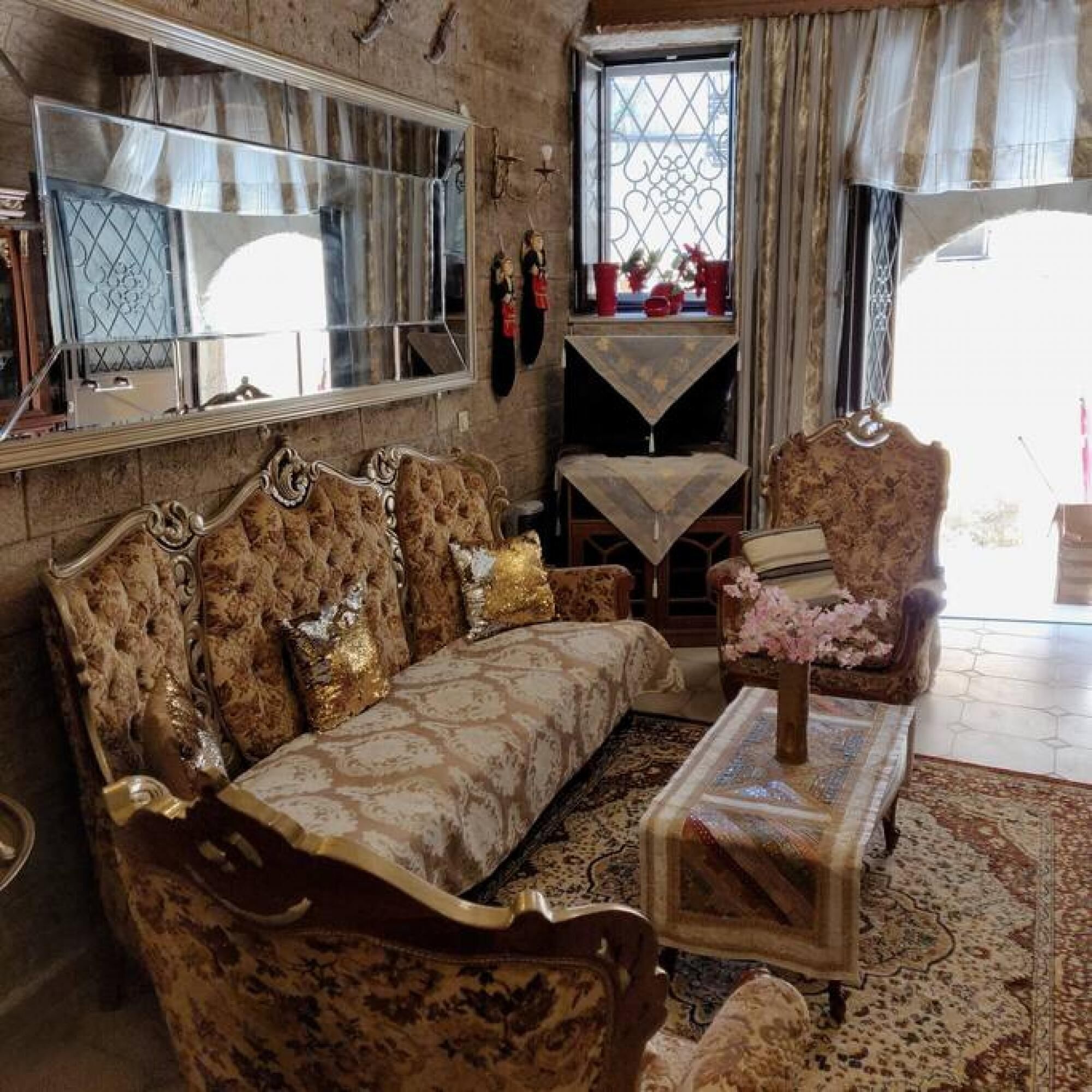 Un salon traditionnel avec un canapé, un fauteuil et une petite table sur laquelle est posé un vase.