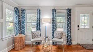 Una habitación con dos sillas, una lámpara y una cesta de mimbre.