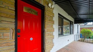 A red door with a mailbox, a stone wall, and a covered porch with a tiled floor. - 5 Minutes From Downtown Atlanta (Atlanta)