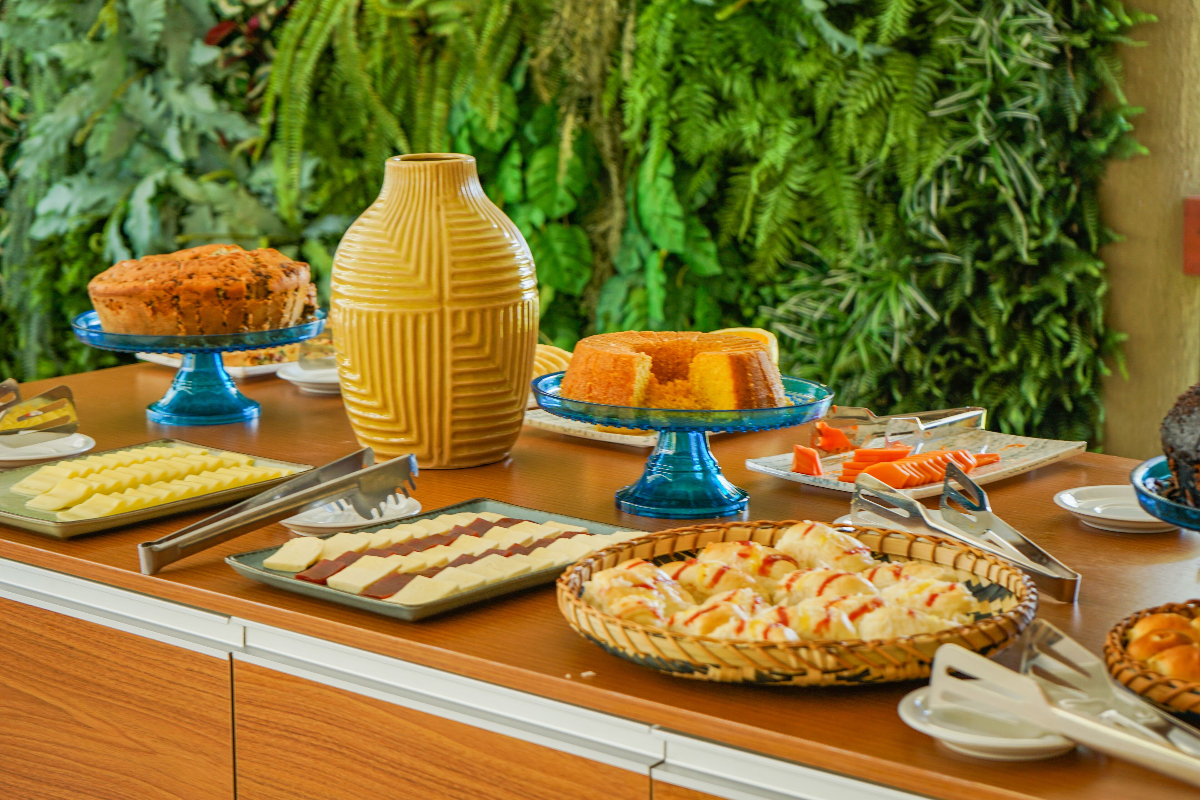 A buffet with various food items and a decorative vase.